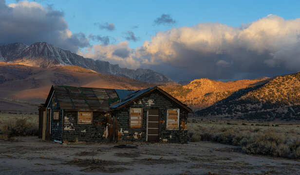 Abandoned old house at sunrise in front of the California Sierra Nevada mountains