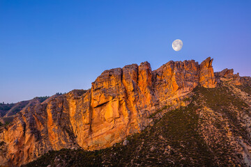 Moon rise over steep cliffs in the desert of Hoya de Guadix, Andalusia, Spain 