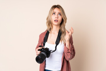 Young photographer girl over isolated background frustrated by a bad situation