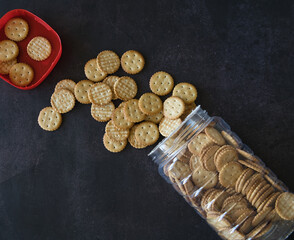 cookies in jar scattered on the table with black background
