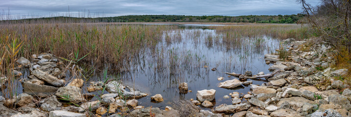 Wetland lake with reeds and rocky shore