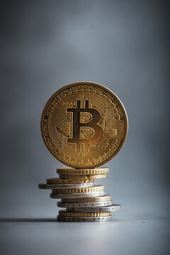 Golden bitcoin coin with euro coins. Euro coins stacked on each other and on the top is bitcoin. Euro versus cryptocurrency.