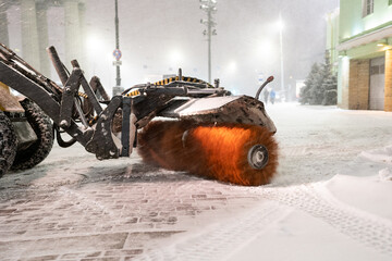 Vehicles for clearing snow. Cropped shot of tractor with rotary broom cleaning sidewalk in winter...