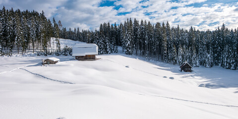 Mountain hut on a snowy alpine meadow