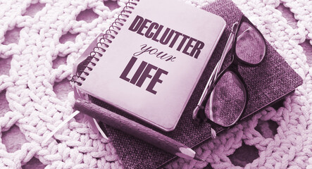 Declutter Your Life on the cover of notebook, eye glasses and pen. Concept meaning Free Less Chaos...