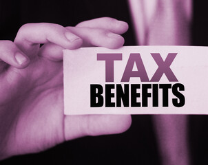 Businessman shows a card with text tax benefits. Taxes and fees policy regulation concept