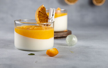 Panna Cotta with orange jelly in a glass on a white background