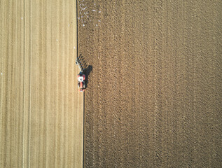 Overhead view of a lone tractor ploughing a sunny field in East Yorkshire, UK