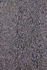 Texture in detail of old asphalt road with gravel or pebbles 