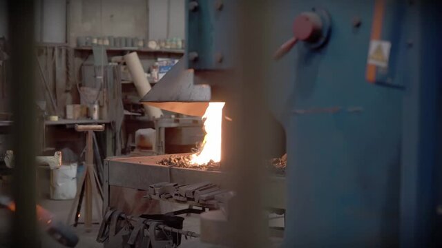 Marteau pilon dans une ferronnerie d'art avec pi&egrave;ce en acier forg&eacute;. Belle flamme dans le feu de la forge.