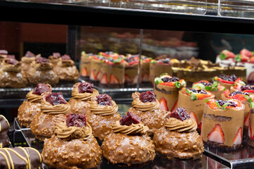 Different coloured chocolates ready to buy. Confectionery. A selection of various delicious chocolate deserts for sale at a market stall. 