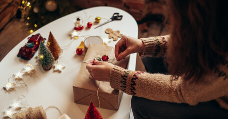 Woman s hands wrapping Christmas gift boxes, close up. Unprepared presents on white table with...
