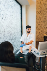 Chiropodist doing an ultrasound test to patient's foot.