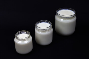 Fresh milk in jar on black background.