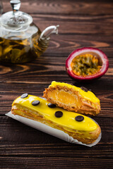 Beautiful and tasty eclair with yellow glaze and mango-passion fruit flavor