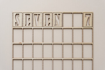 the number 7 spelled out in wooden stencil font inside a grid