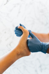 Close up of a podiatrist hands with medical gloves exploring the foot of a patient in the podiatry...
