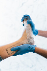 Close up of a podiatrist hands with medical gloves exploring the foot of a patient in the podiatry...