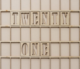 the number 21 spelled out in wooden stencil font inside a grid