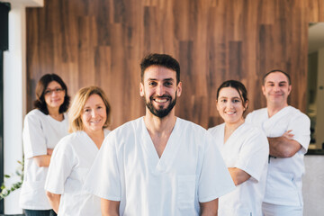 Chiropodists team doctors looking at camera and smiling in medical center with white medical gown.
