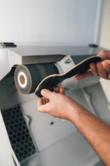 Chiropodist sanding and polishing an orthopedic foot insole for a patient.