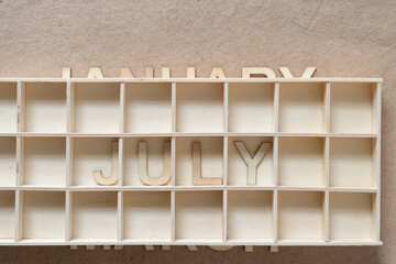 the month of july arranged in a shallow wooden box