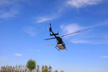 an agricultural helicopter flying against American white moth flies from the landing point to the spraying area, North China