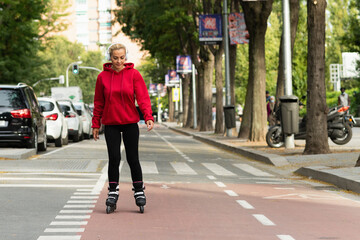 Adult woman skating with inline skates in the city