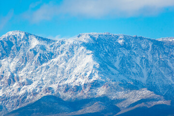 snow covered mountains against a blue cloudy sky