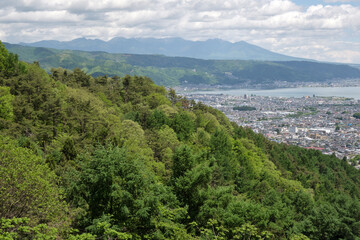 Fototapeta na wymiar 新緑の季節の岡谷市の町並みと諏訪湖