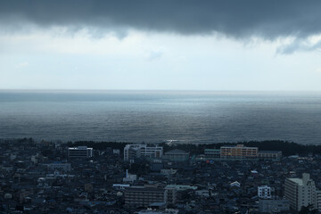 朝の雨が降る港町の街並み　
