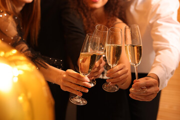 Friends with glasses of sparkling wine celebrating New Year, closeup