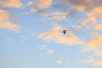 朝焼けの雲と高く舞い上がった赤い熱気球