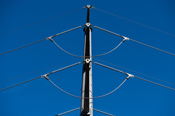 High voltage power line towers shot from below on a sunny day and blue sky.