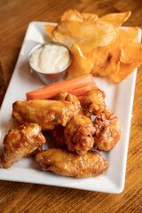 A plate of chicken wings with potato chips and a Canadian Caesar cocktail.