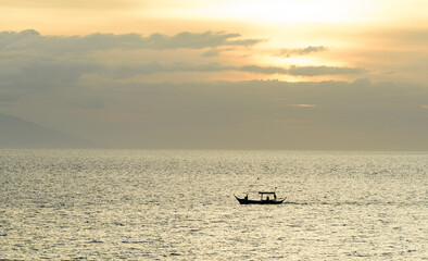 Obraz premium A gorgeous sunset over the Pacific Ocean with silhouette shots of fishing boats. 