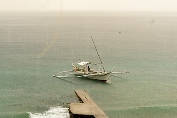 Filipino Banca boats being drenched by a midday rain shower.  