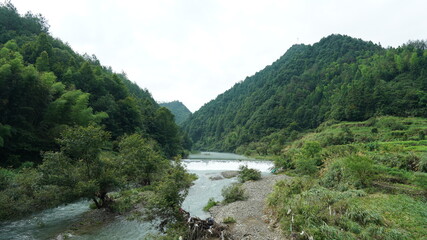 The beautiful countryside view with the waterfall flowing in the mountains after the rainy day