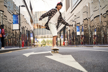 teenage asian boy skateboarding outdoors © imtmphoto
