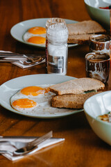 Fried eggs and bread in white plate for breakfast on wooden table