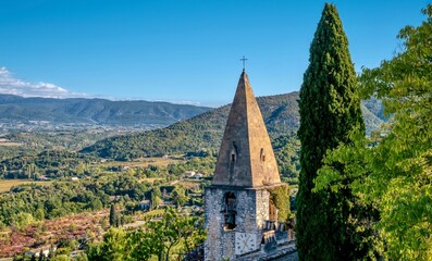 The medieval church spire and wide angle view of the scenic landscape surrounding the hilltop village of Crestet in the Vaucluse region of Provence, France.