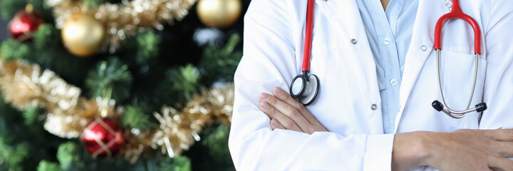 Woman doctor with stethoscope standing near christmas tree closeup