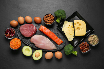 Different fresh products on black table, flat lay. Sources of essential amino acids