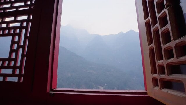 Awesome mountains in blue mist, panorama from open window in buddhist monastery