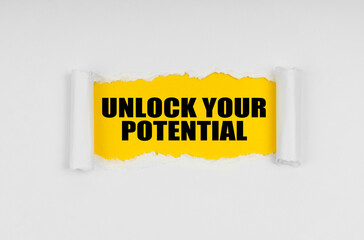 A window is made in the paper, where on a yellow background the inscription - Unlock Your Potential