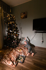 child playing near christmas tree