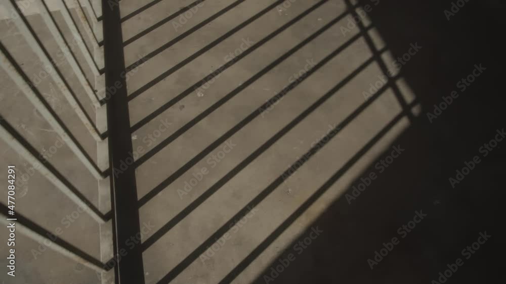 Aufkleber shadows of a closing gate with bars in a dark building