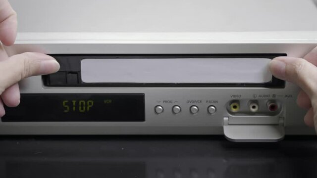 VHS videocassette is put into the VCR to watch the video. Close-up of a videotape. 