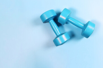  flat lay of blue dumbbells on blue background with copy space. Sports and healthy lifestyle concept.