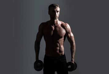 Fototapeta na wymiar Sexy sporty torso, man with dumbbells. Portrait of athletic man with dumbbells. Shirtless man man with muscles torso in studio.